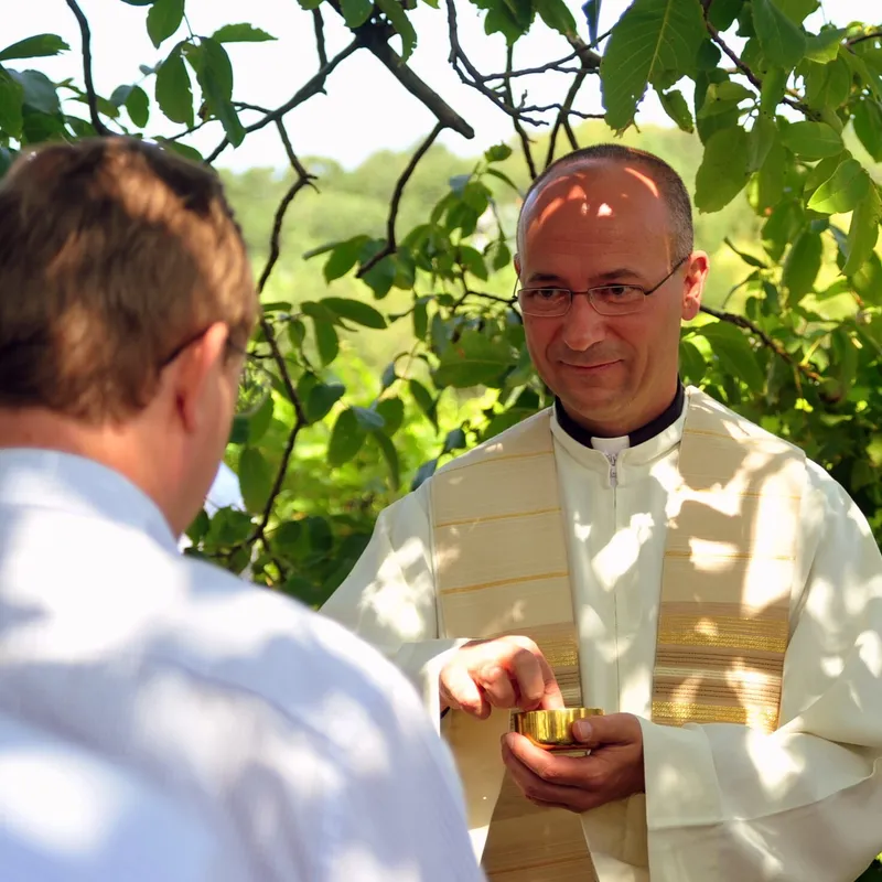 Priester teilt die Kommunion aus