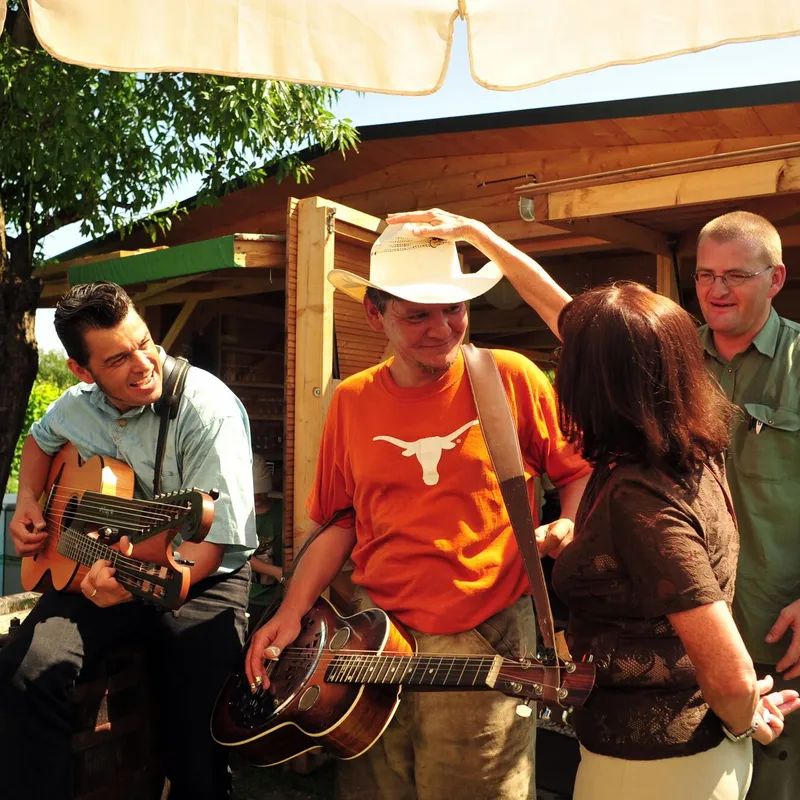 Musiker mit Gitarre und Cowboyhut spielen für die Gäste
