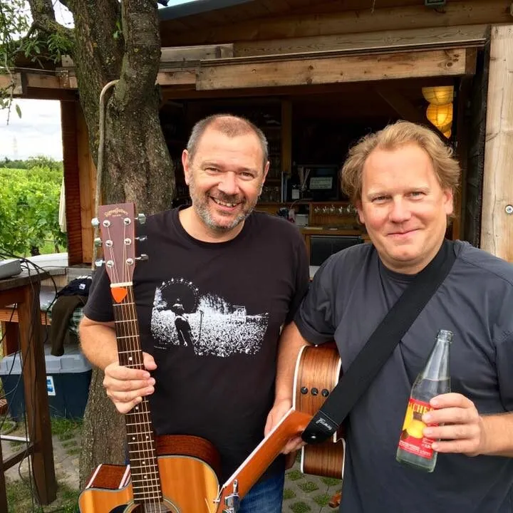 Zwei Musiker mit Gitarren vor der Buschenschank