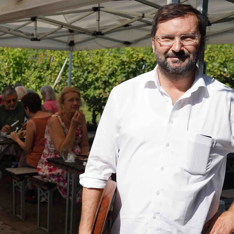 Norbert Walter im weißen Hemd vor den Gästen der Buschenschank