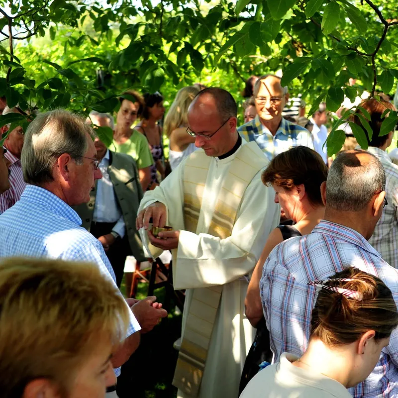 Priester im Messgewand inmitten der Gäste