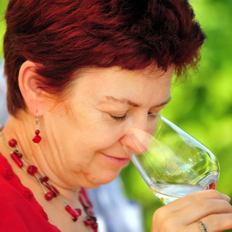 Frau riecht an einem Glas Weißwein